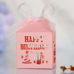 Macro detail of pink laser-cut Happy Birthday candy box with white ribbon bow