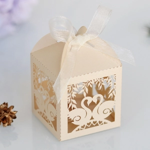 Detailed laser-cut wedding candy box with elegant swan heart pattern and ribbon