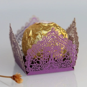 Macro detail of laser-cut purple lace candy box with intricate floral patterns for weddings