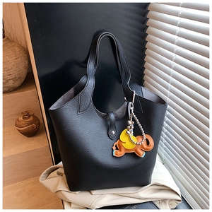 Detail of black lychee grain leather bucket bag with an elephant charm and silver hardware