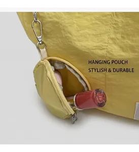 Detail of round yellow nylon mini pouch with D-ring hook attached to canvas tote bag