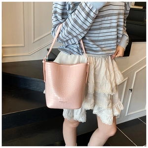 Close-up of pink crocodile pattern bucket bag with fashion leather inscription detail
