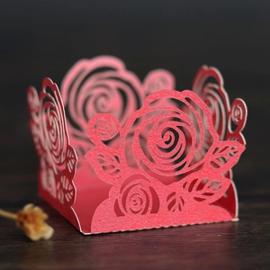 Détail macro de caissettes à cupcakes rouges découpées au laser avec motifs de roses