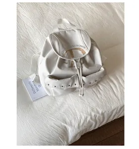 Vue détaillée du sac à dos en nylon blanc crème avec rivets et imprimé de lettre D vintage