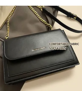 Detail of black flap shoulder bag with gold chain strap and FASHION & BAGS gold lettering