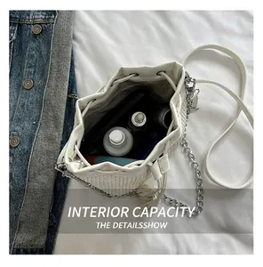 Overhead view showing interior storage of white woven bucket bag with chain strap
