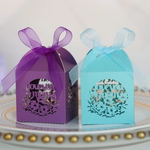 Détail de boîtes cadeaux 'Love You Mom' découpées au laser en bleu et violet avec ruban