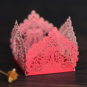 Detail of red laser-cut floral lace pattern on wedding candy gift box with scalloped edges