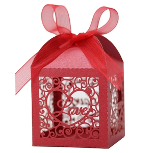 Detailed laser-cut Love heart pattern on red pearlescent paper gift box with ribbon