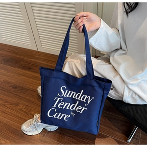 Dettaglio della borsa tote in tela blu navy con stampa di lettere Sunday Tender Care