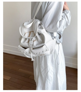 Détail du sac à dos en nylon blanc avec grand logo V et rivets sur la poche latérale