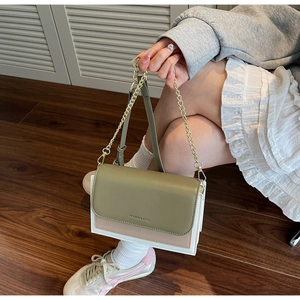 Detailed side view of tri-color patchwork leather crossbody bag with chain and leather strap