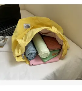 Close-up of a large yellow canvas tote bag showing internal capacity and pockets