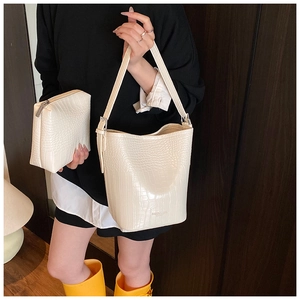 Detail of off-white crocodile embossed bucket bag and matching pouch with fashion text