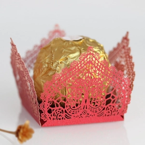 Macro shot of red laser-cut lace candy box with tree texture and chocolate holder