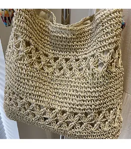 Detailed view of the hollow weave pattern and fabric lining on this beige straw tote bag