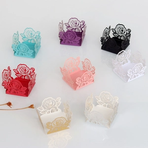 Détails de motifs de roses découpés au laser sur des boîtes de faveur de mariage colorées