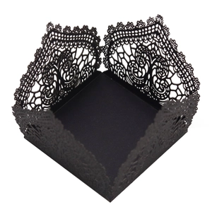 Detail of laser-cut black lace gift box with intricate floral vine patterns for weddings
