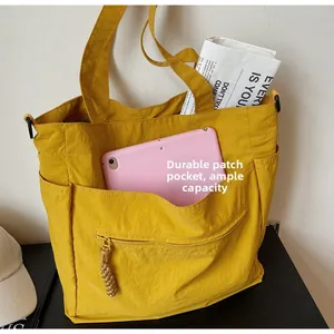 Close-up of ginger yellow tote bag with large capacity, side pockets and woven puller