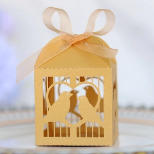 Détail de boîte à bonbons dorée découpée au laser avec motif cœur et nœud en ruban