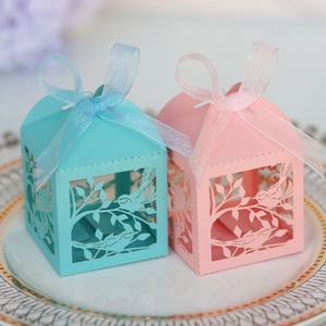 Macro detail of laser-cut bird gift boxes with elegant ribbons on a vintage plate