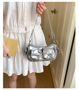 Détail du sac bandoulière argenté métallisé avec nœuds et style esthétique Y2K