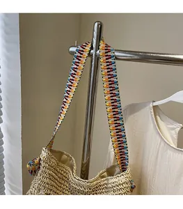 Close-up of bohemian beige woven tote bag with vibrant colorful jacquard ribbon strap