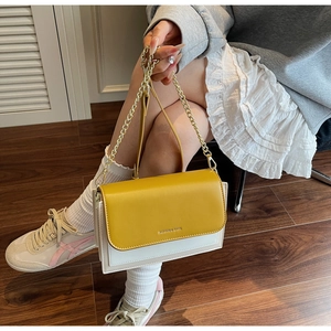 Detail of yellow and white leather flap bag with chain strap and fashion print