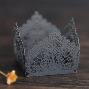 Close-up of elegant black laser-cut lace pattern on a wedding party candy gift box