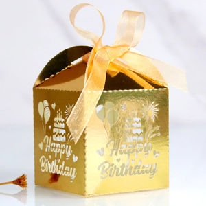 Détail de la boîte à bonbons dorée découpée au laser avec design Happy Birthday et ruban