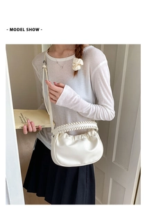 Creamy white ruched cloud bag with woven handle shown styled on model for daily commute
