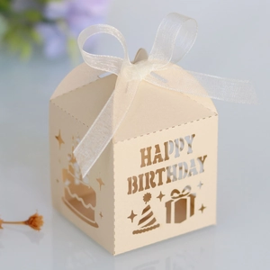 Detail of laser-cut Happy Birthday candy box with elegant white ribbon and star patterns