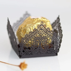 Macro detail of laser cut hollow candy box with intricate black vine pattern lace