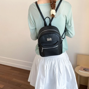 Détail de la texture cuir PU litchi noir avec logo de marque en métal argenté sur le sac