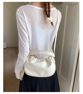 Detail of the white ruched cloud bag showing the thick braided handle and soft texture
