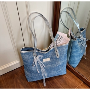 Blue denim tote bag detail with pearl lace bow and silver mirror leather handles