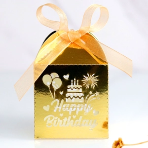 Gros plan sur boîte à bonbons dorée Happy Birthday avec découpe laser et ruban de soie
