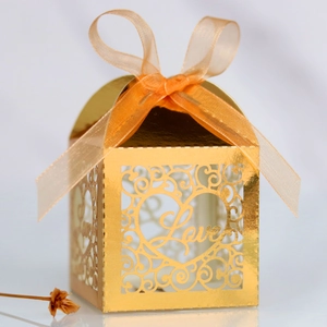 Detail of laser-cut heart pattern and Love text on golden pearlescent wedding favor box