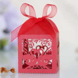 Detailed laser-cut red wedding favor box with swan heart design and organza ribbon