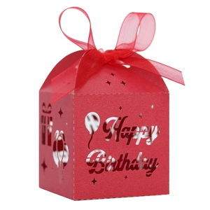 Close-up of red laser-cut Happy Birthday candy box with balloon patterns and ribbon
