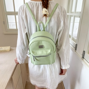 Vue arrière du mini sac à dos vert menthe en cuir grainé porté par un mannequin