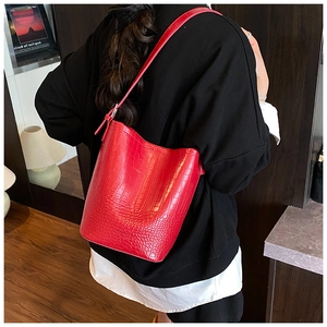 Detail of red crocodile pattern bucket bag showing textured leather and embossed logo