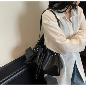 Detail of black textured tote bag with silver metal rings and mini flap coin pouch