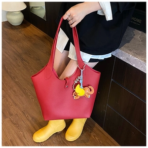 Close-up of red lychee pattern leather tote bag with colorful elephant charm detail