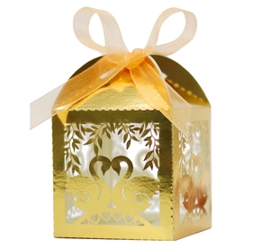 Macro detail of laser-cut swan pattern on a golden pearlescent wedding favor gift box