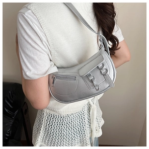 Close-up of metallic silver crescent bag featuring buckle details and lychee texture