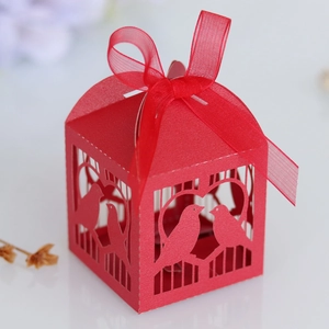 Détail d'une boîte à dragées rouge découpée au laser avec ruban et motifs oiseaux