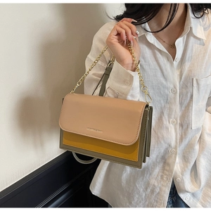 Detail view of the tricolor square bag featuring a gold chain strap and embossed text