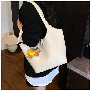 Close-up of off-white tote bag in pebbled leather with a cute elephant leather charm