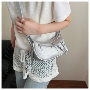 Model wearing a silver lychee texture half-moon crossbody bag with metallic details